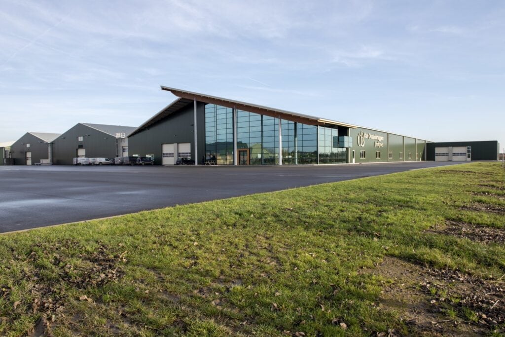 Bedrijfsgebouw met moderne architectuur en grote glazen ramen voor optimale lichtinval.