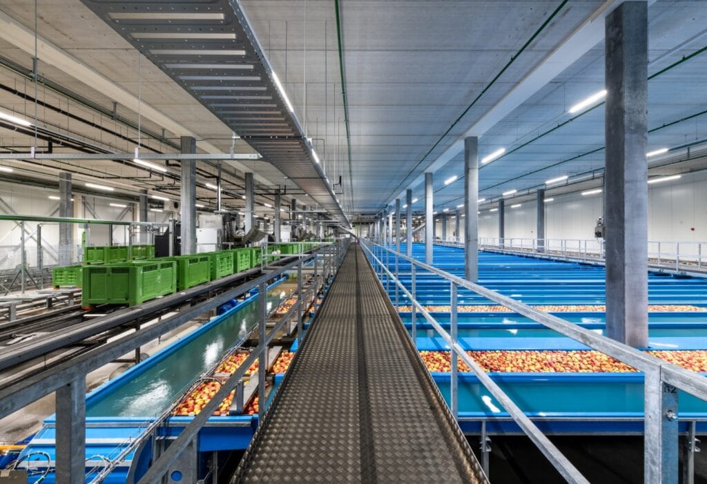 Industriële fabriek met geavanceerde conveyor systemen en opslagruimtes.