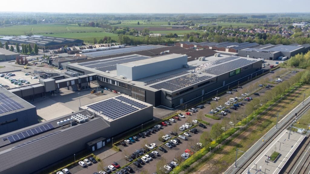 Groot industrieel gebouw met zonnepanelen en parkeerplaatsen, gebouwd door JCVANKESSEL BOUW.