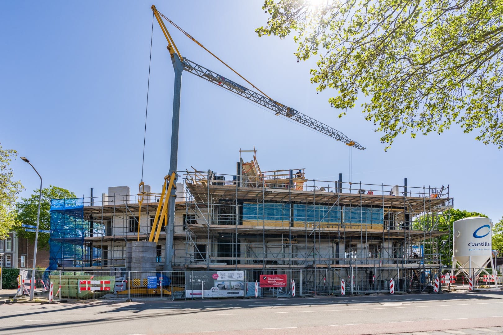 Bouwplaats van JCVANKESSEL BOUW met grote kraan en scaffolding, klaar voor nieuw bouwproject in Nede.