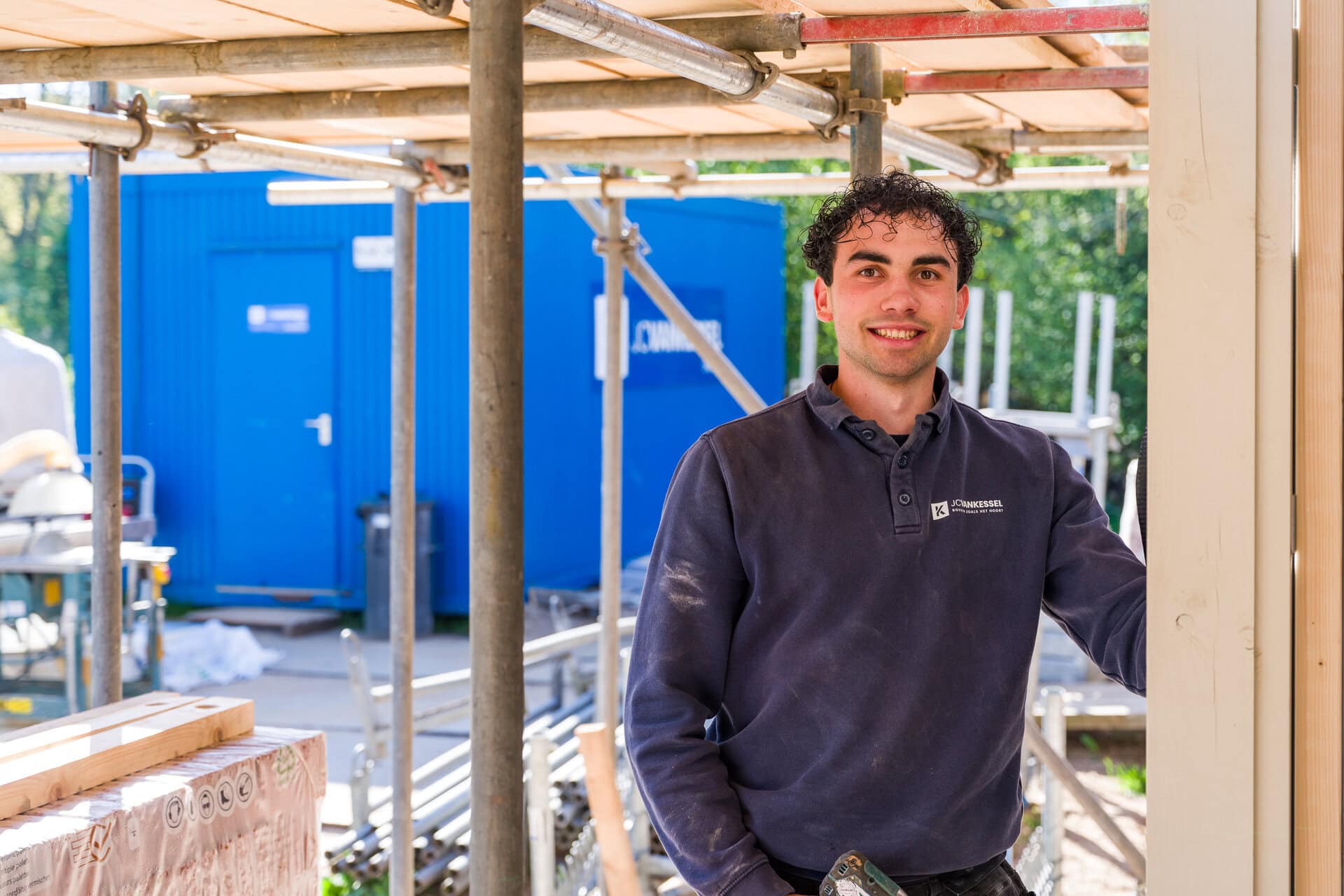 Bouwvakker op een bouwplaats met houten en metalen constructie, klaar voor nieuw project.