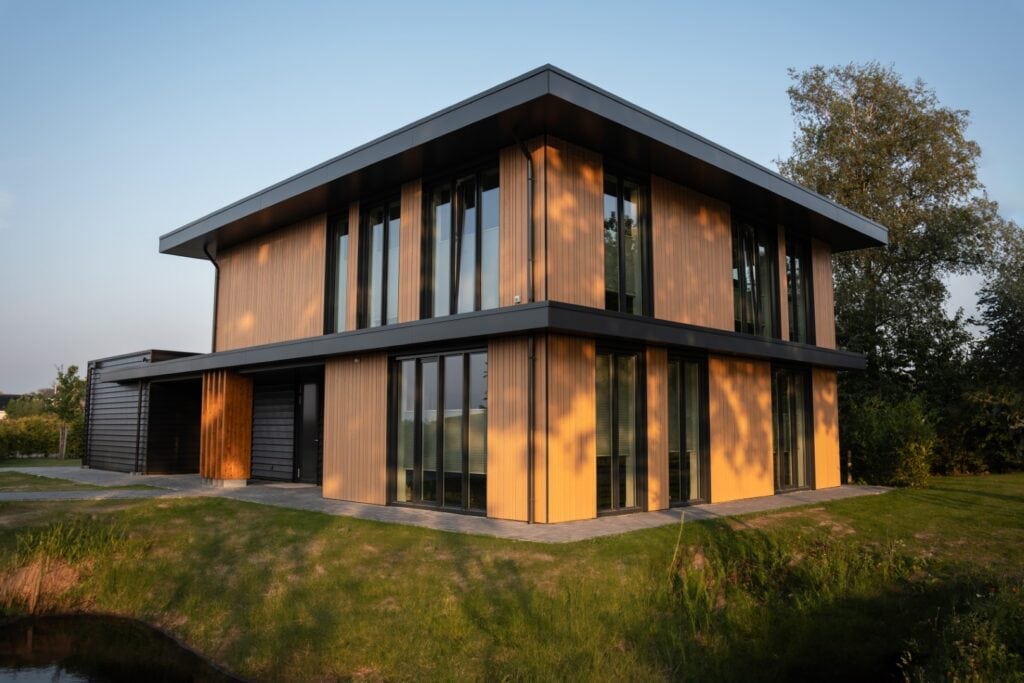 Moderne houten woning met grote ramen en strakke architectuur.