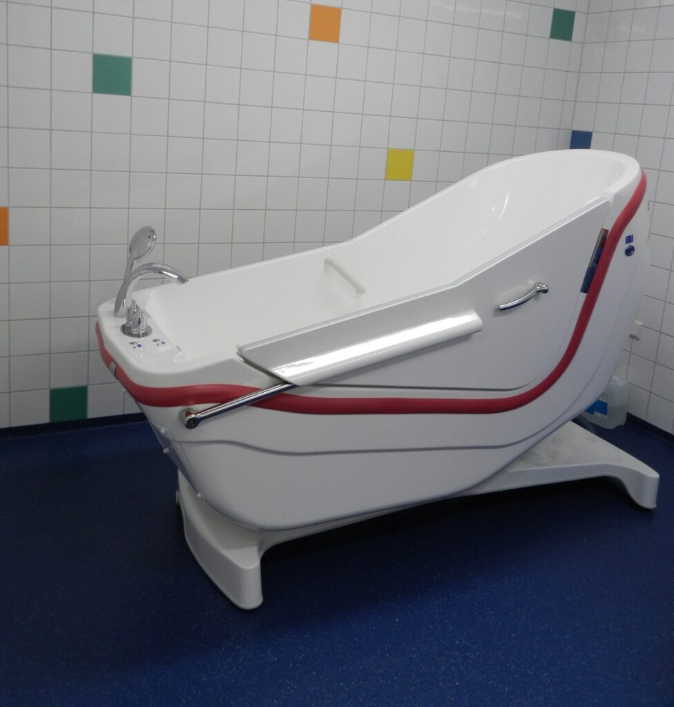 Therapiebad voor zorgpaviljoen met antislip vloer en kleurrijke wandtegels.