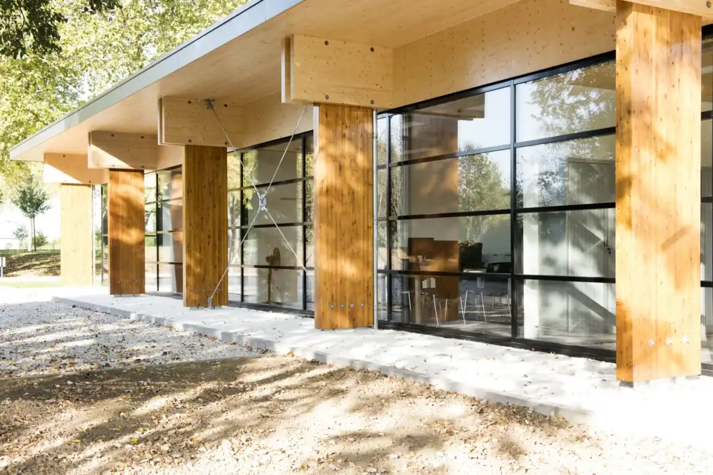 Moderne houten gebouw met grote glazen ramen en houten kolommen.