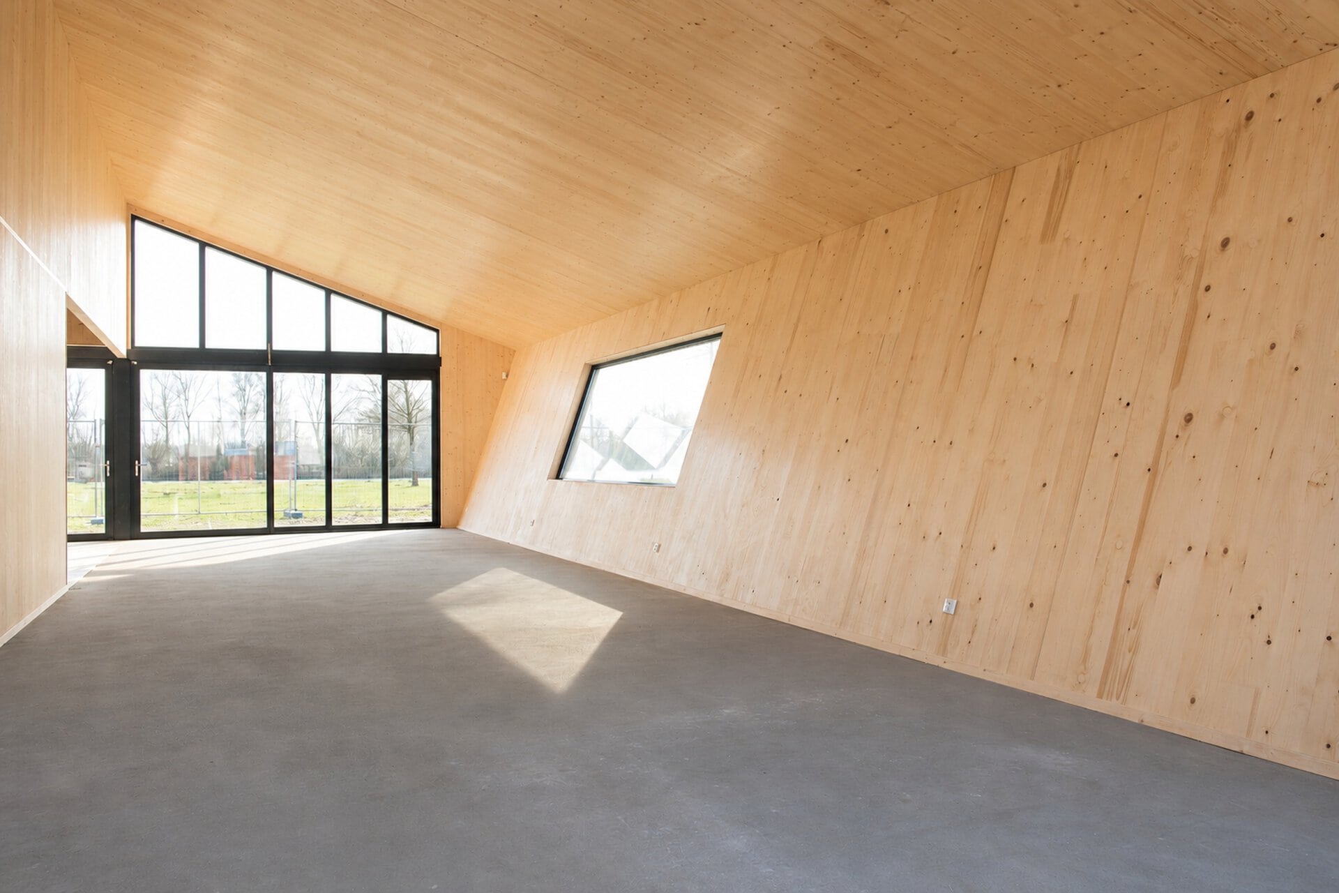 Modern interieurruimte met houten wanden en grote glazen deuren.